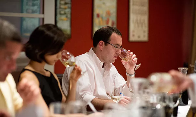 People toast with wine glasses at the Institute of Culinary Education.