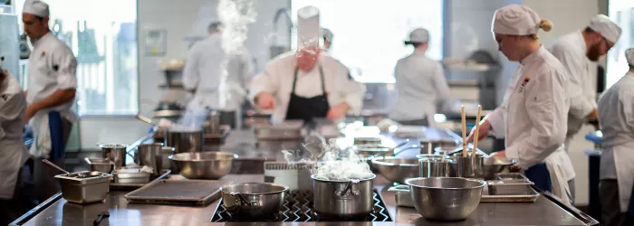 Chefs and students cook in a kitchen