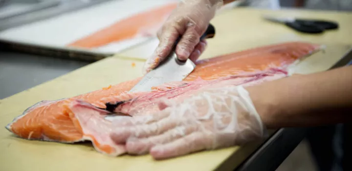 professional cook slicing smoked salmon with wustoff knife