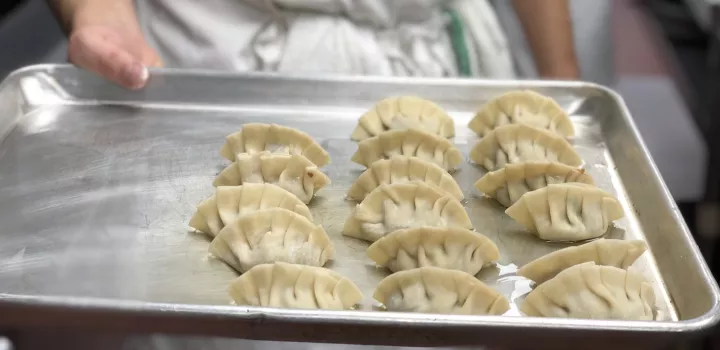 Chinese dumplings sit on a metal tray