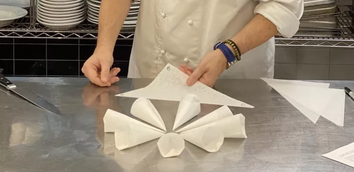 Chef Chavez demonstrates making a parchment paper piping bag