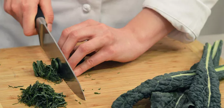 Hands chop kale