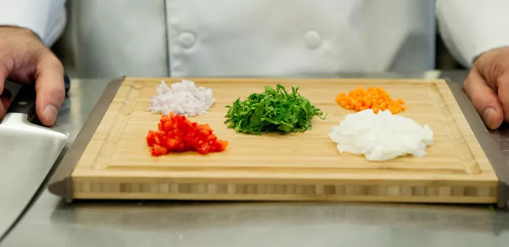 A chef demonstrates knife skills with vegetables
