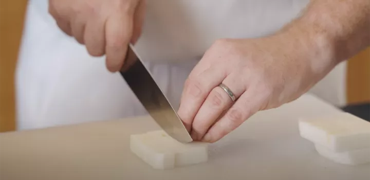 Chef Chris Arturo uses a knife to cut a turnip