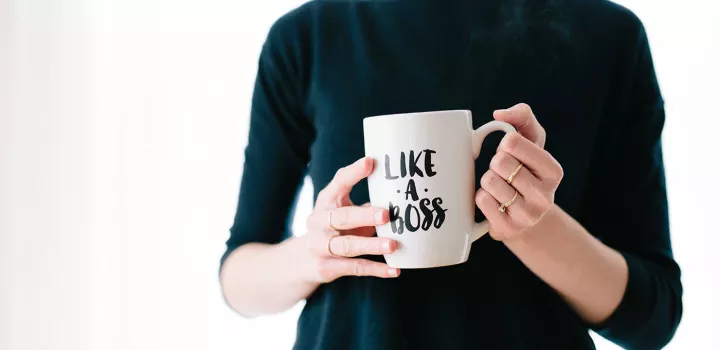 woman holding a like a boss mug