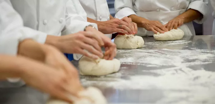 Pastry students knead dough.
