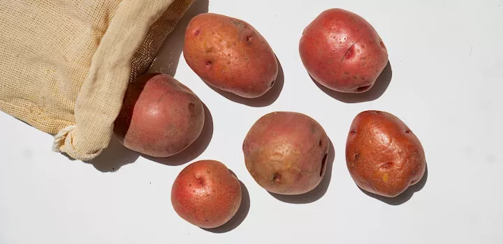 Potatoes falling out of a burlap sack