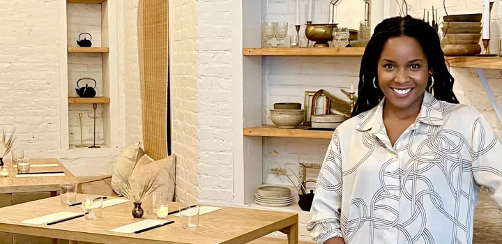 Chef Rasheeda Purdie stands in front of a wooden table