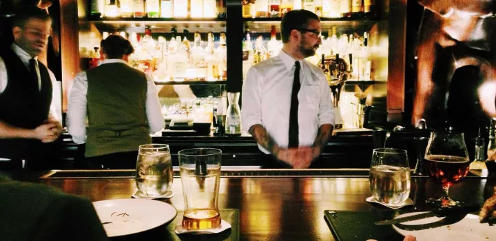 bartender behind a busy cocktail bar