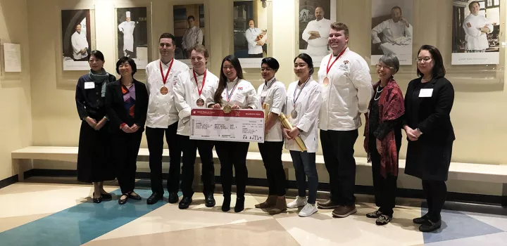 Amanda Lee holds her boarding pass prize after winning the United States of Umami Culinary Competition