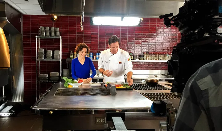 Dana Cowin prepares a dish at ICE on camera.