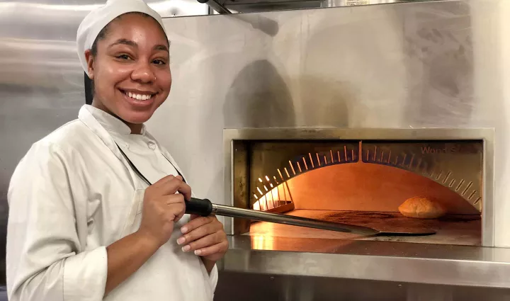 ICE Student Putting Bread in Pizza Oven