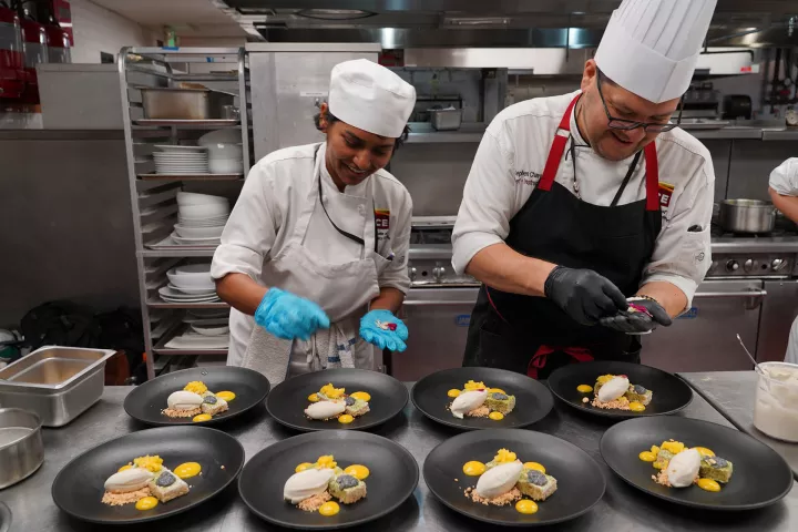 Student and chef plating dishes for los angeles plant based culinary program