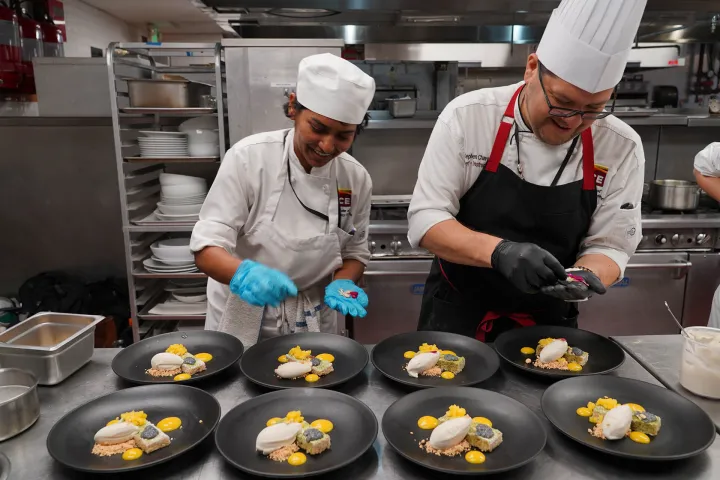 Student and chef plating dishes for los angeles health centered culinary program